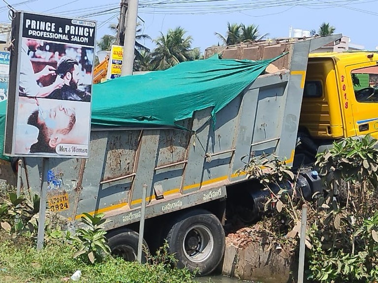 వంతెన విరిగి కాలువలో దిగబడిన ఇసుక లారీ